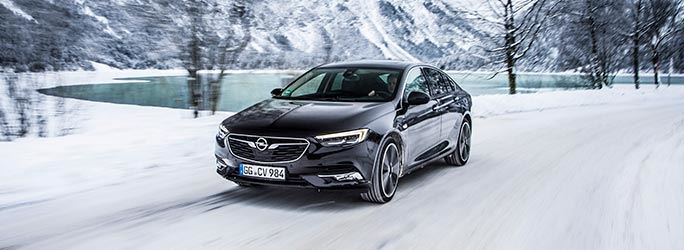 Opel Insignia zwart rijdt op sneeuw 